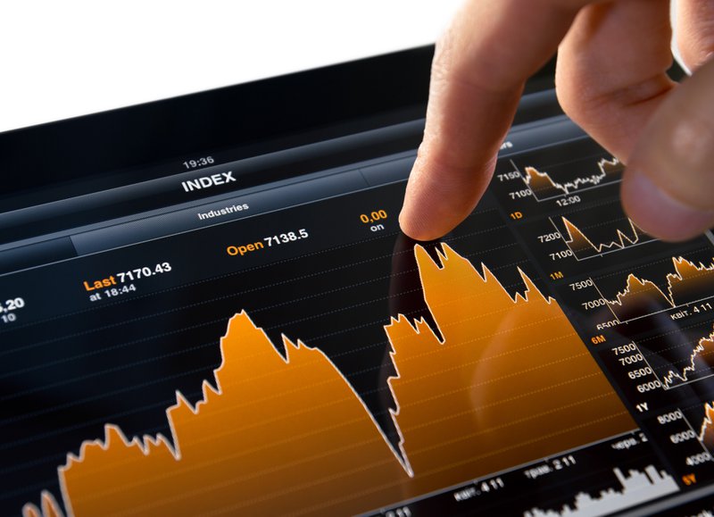 person touching a stock market graph on a tablet